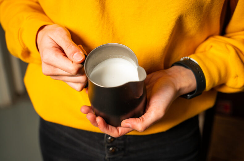 Foto di una lattiera da bar per montare il latte con dentro il latte montato lucido, cremoso e elastico e senza bolle!