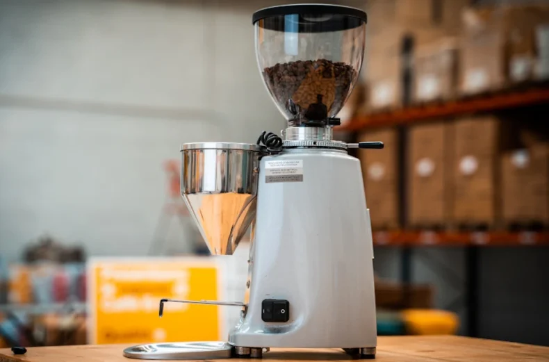 Copertina dell'articolo di Caffè Ernani "Come scegliere il macina caffè per casa" con in primo piano un macinino elettrico professionale della Fiorenzato